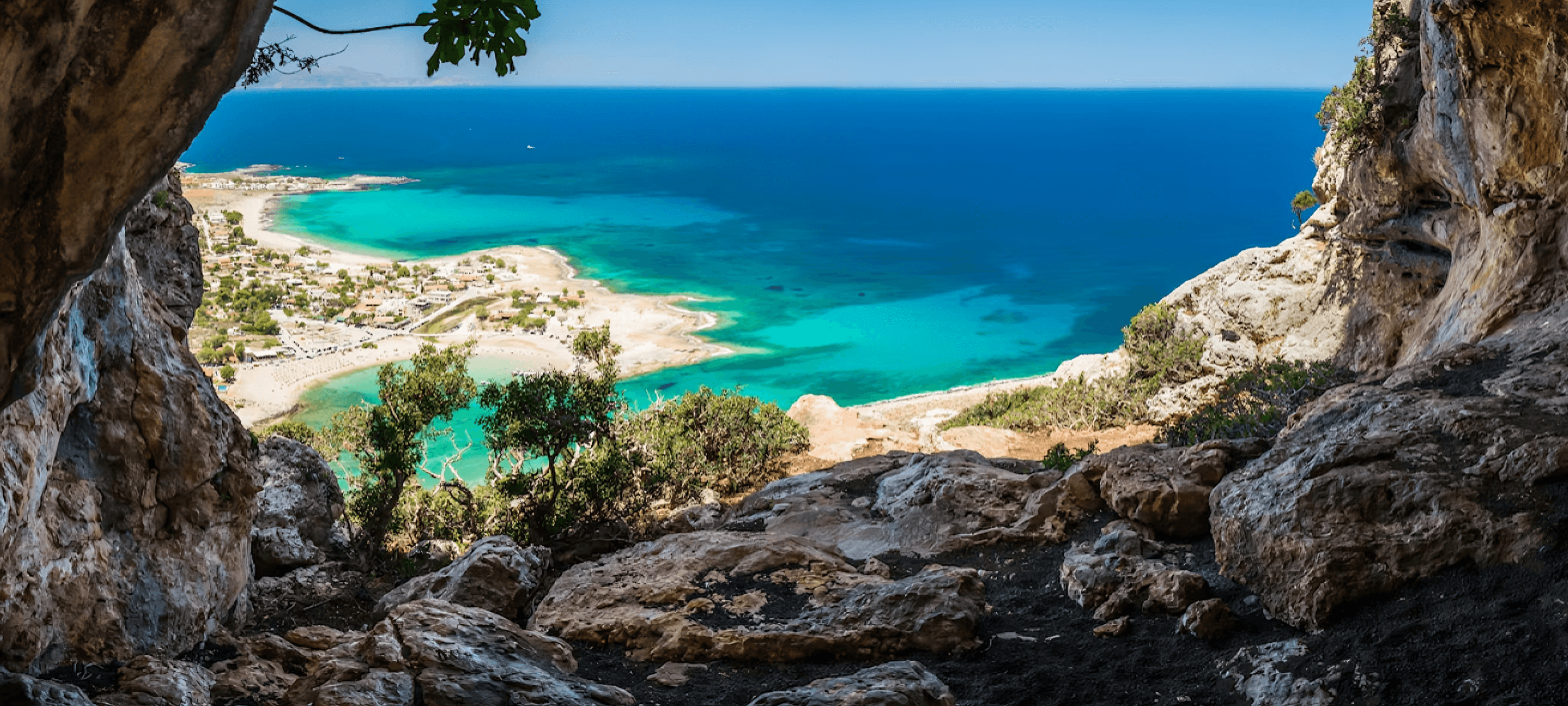 Aerial view of a turquoise lagoon in western Crete, framed by coastal rock formations